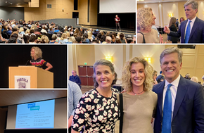 A speaker addresses a large audience in an auditorium.