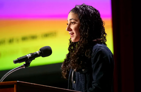 Meital Kochinski speaking at a podium