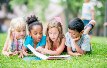 Kids reading on grass
