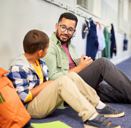 Student talking with a school counselor in a hallway