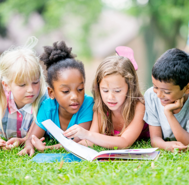Kids reading on grass