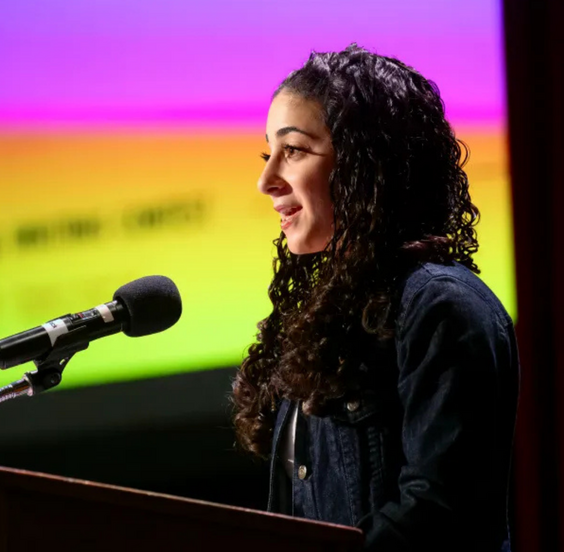 Meital Kochinski speaking at a podium