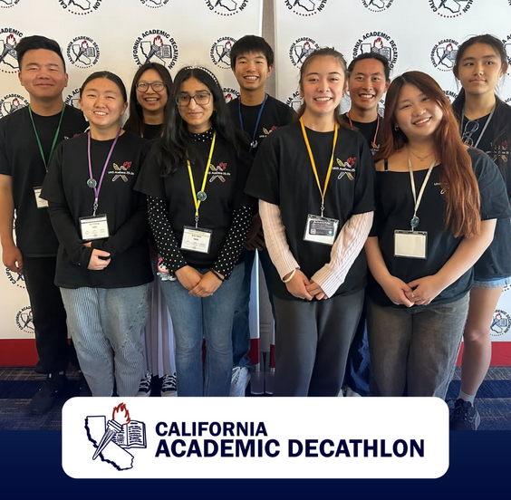 A group of smiling students in black t-shirts stand together, posing for a photo.