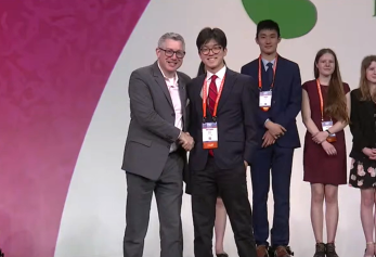 Matthew Chang shaking hands after winning first place in Microbiology