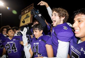 A handful of Portola football players posing and smiling with CIF winning plaque