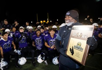 Portola head coach Peter Abe posing with CIF winning plaque