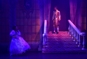 Woodbridge High School students performing a scene from Cinderella with a staircase set and dramatic lighting.