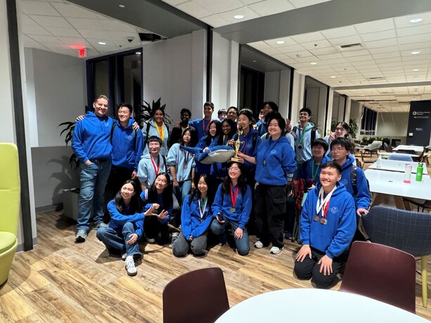 University High School team  proudly poses with a trophy and medals.