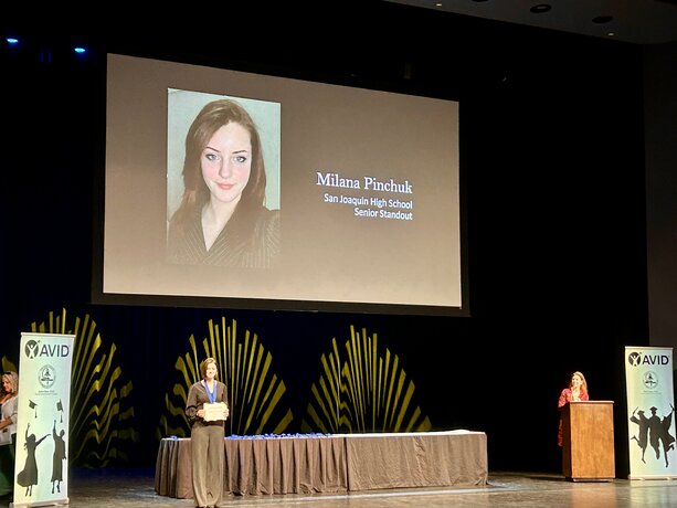 Milana Pinchuk holding award on stage