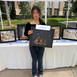  Nianci (Grace) Liu posing to camera with her art piece.