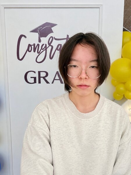 Yura Shaktilavi in front of graduation sign