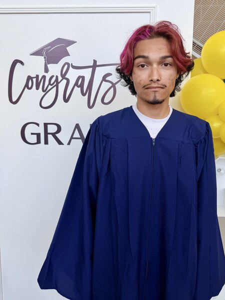 Ethan Griffith standing in front of graduation sign