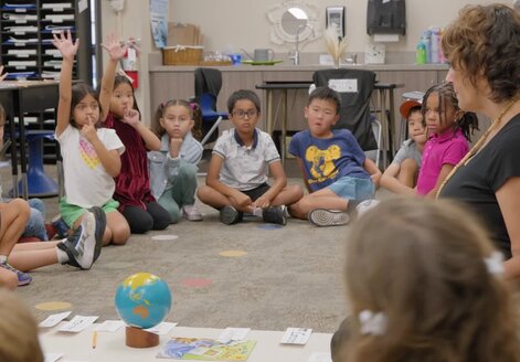 teacher on the floor with her young students