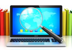laptop with magnifying glass and books